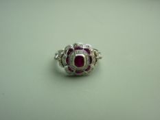 A FOURTEEN CARAT WHITE GOLD RUBY & DIAMOND FANCY CLUSTER DRESS RING having a centre oval ruby with