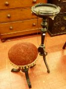 AN EBONIZED EMPIRE STYLE BOWL STAND and a rise and fall piano stool with circular top, the stand