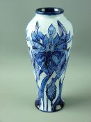 A MOORCROFT MODERN FLORIAN WARE STYLE VASE decorated with tonal blues on a sky blue background,