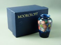 A MOORCROFT 'CLEMATIS' TAPERING SHOULDERED VASE, decorated on a tonal blue ground, 10.5 cms high,