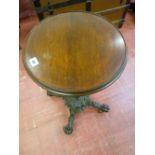 A VICTORIAN CAST IRON TABLE BASE with circular mahogany top, the 37 cms diameter top on a brass