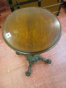 A VICTORIAN CAST IRON TABLE BASE with circular mahogany top, the 37 cms diameter top on a brass