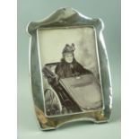 A HALLMARKED SILVER PHOTOGRAPH FRAME with wooden easel stand, inscribed to the front 'Charlotte