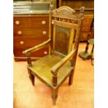 A 1930's CARVED OAK ANGLESEY EISTEDDFOD CHAIR, the shaped top rail with carved leeks and spindle