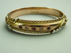 A NINE CARAT GOLD HOLLOW BANGLE, half decorated with a centre oblong band having three small