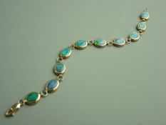 A NINE CARAT GOLD OPAL BRACELET of ten oval mid blue opals in small circular gold links, total