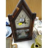 A vintage American architectural mantel clock with painted beehive style door