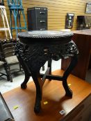 A carved ebonized wood & marble topped planter stand