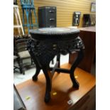 A carved ebonized wood & marble topped planter stand