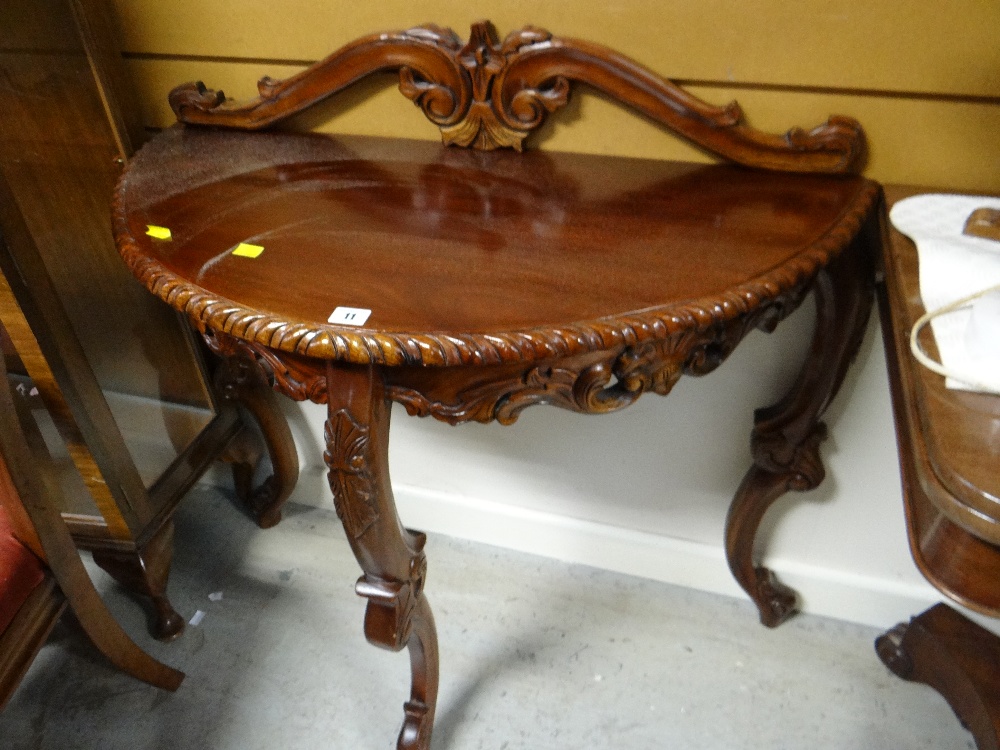 A nicely carved mahogany demi-lune hall table together with a carved rail back