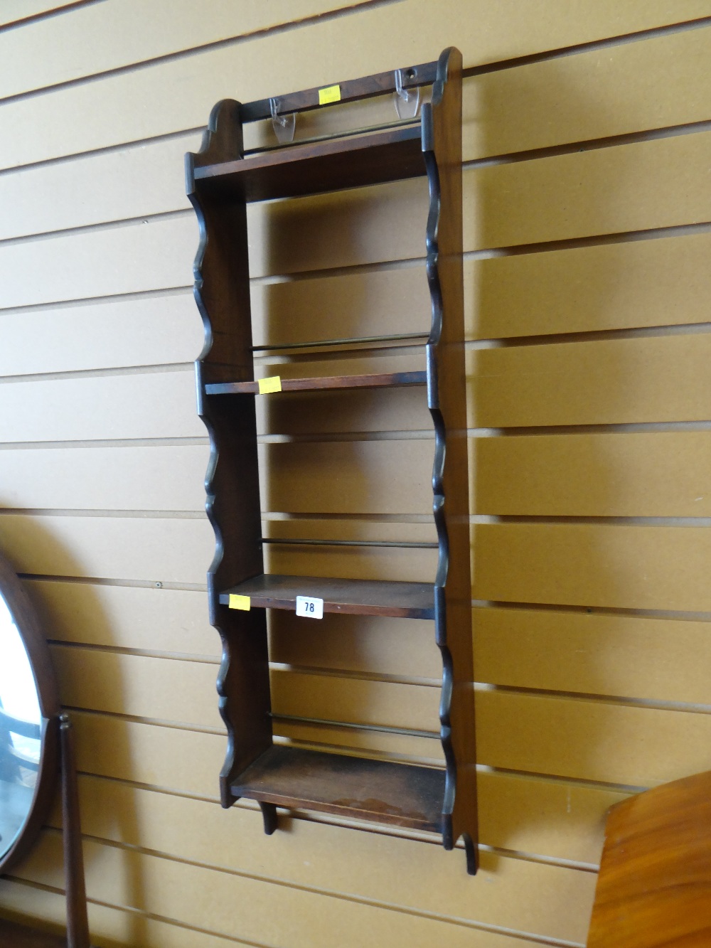 A mahogany narrow hanging shelf unit