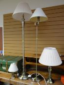 Two modern brass effect standard lamps together with two similar table lamps
