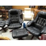 A pair of black leather swivel armchairs together with matching footstools