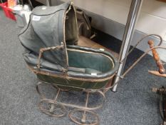 A Victorian child`s doll`s pram with green leather padded sprung carriage