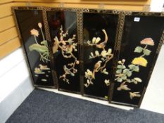 Four black lacquered Chinese panels with birds & foliage in relief