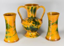 AN EWENNY POTTERY VASE TRIO in mottled green and orange glaze, the imposing centre vase of archaic