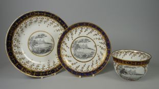 A SWANSEA PORCELAIN TRIO WITH TOPOGRAPHICAL SCENES being a cup, plate and saucer with a monochrome