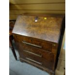 A polished three-drawer sloped vintage bureau