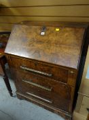 A polished three-drawer sloped vintage bureau