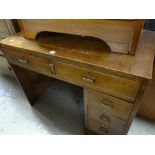 A vintage writing desk with a bank of four short & two knee high drawers