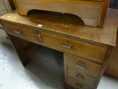 A vintage writing desk with a bank of four short & two knee high drawers