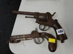 An antique revolver gun & an earlier pistol (distressed)