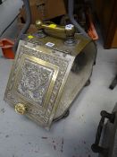 A decorative brass sloped coal box