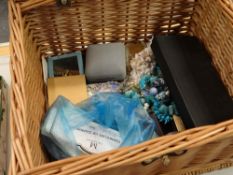 A wicker basket containing costume jewellery including an amber ring & brooch