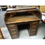 An English-made oak roll top desk with two banks of four drawers & pigeon hole interior (key with