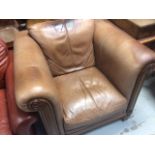 A modern light brown leather & wooden framed club-style armchair