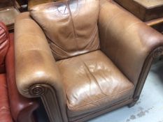 A modern light brown leather & wooden framed club-style armchair