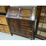 A vintage oak Jacobean-style three-drawer sloped bureau