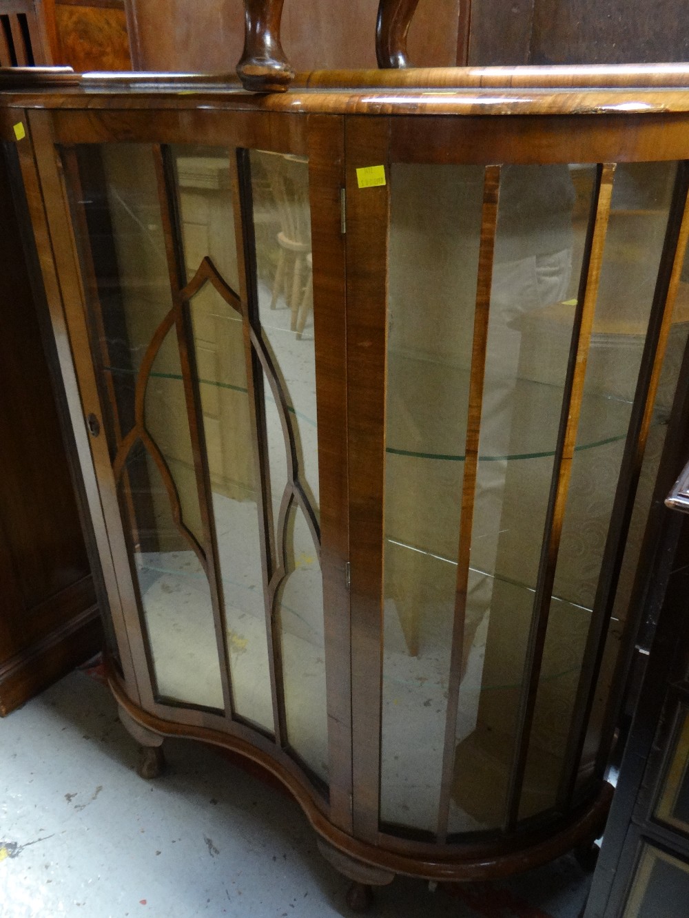 A polished single-door serpentine front china cabinet