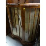 A polished single-door serpentine front china cabinet