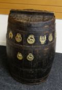 A NINETEENTH CENTURY WOODEN BEER BARREL with ironwork banding and mounted with eight old horse bras