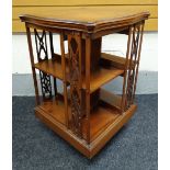 AN EDWARDIAN MAHOGANY ROTARY BOOKCASE having a shaped top and openwork bookends, 53cms squared