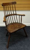 A JOINED SOLID SEAT WINDSOR-STYLE ELBOW CHAIR having splayed supports & two-stage spindle back