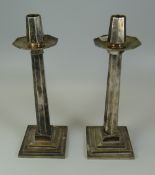 A PAIR OF HEAVY QUALITY EPNS CANDLESTICK HOLDERS of angular form with stepped bases, 27cms high (co