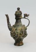 AN ARCHAIC ORIENTAL BRONZE EWER with raised figural decoration, dragon handle and loose lid, 17cms