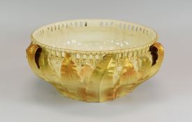A ROYAL WORCESTER LEAF-FORM BOWL with three handles, basket-weave moulding and having an arcaded