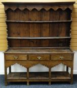 AN EARLY NINETEENTH CENTURY WELSH OAK DRESSER having a flat platform-base, carved frieze and three