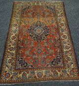 A WELL WORN RED & BLUE GROUND RUG with traditional medallion design, 207 x 137cms