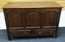 AN EARLY NINETEENTH CENTURY OAK BLANKET CHEST having a hinged lid to reveal candle box with internal
