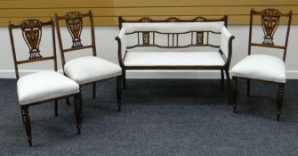 A DELICATE EDWARDIAN INLAID MAHOGANY SETTEE together with three similar but non-matching chairs, all