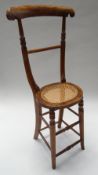 AN UNUSUAL VINTAGE WOODEN CHILD'S CORRECTION CHAIR with cane work oval seat & with high back, 94cm
