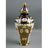 A ROYAL CROWN DERBY VASE of tapered form to a slim base and with a gilt knopped lid, 22 cms high