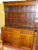 AN EARLY 19th CENTURY NORTH WALES OAK DRESSER, the extended canopy rack with three plate shelves and