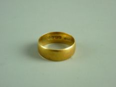 AN EIGHTEEN CARAT GOLD WIDE WEDDING BAND, 6.5 grms