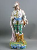A CONTINENTAL PORCELAIN, BELIEVED VOLKSTEDT, EXTRAVAGANTLY DRESSED STANDING GENTLEMAN with feathered