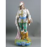 A CONTINENTAL PORCELAIN, BELIEVED VOLKSTEDT, EXTRAVAGANTLY DRESSED STANDING GENTLEMAN with feathered